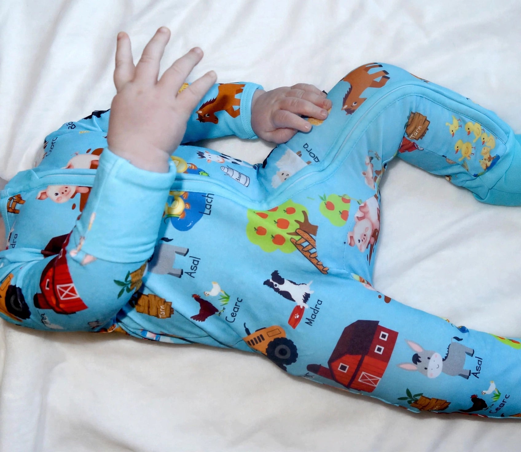 Smiling toddler wearing a red zipped sleepsuit